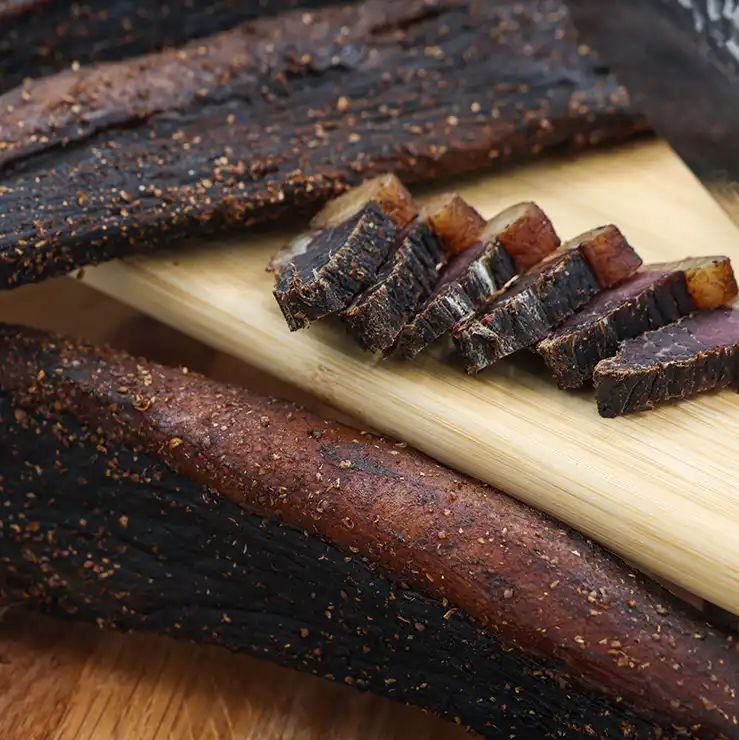 Pile of sliced beef biltong with a dark smokey BBQ seasoning at The Village Butcher