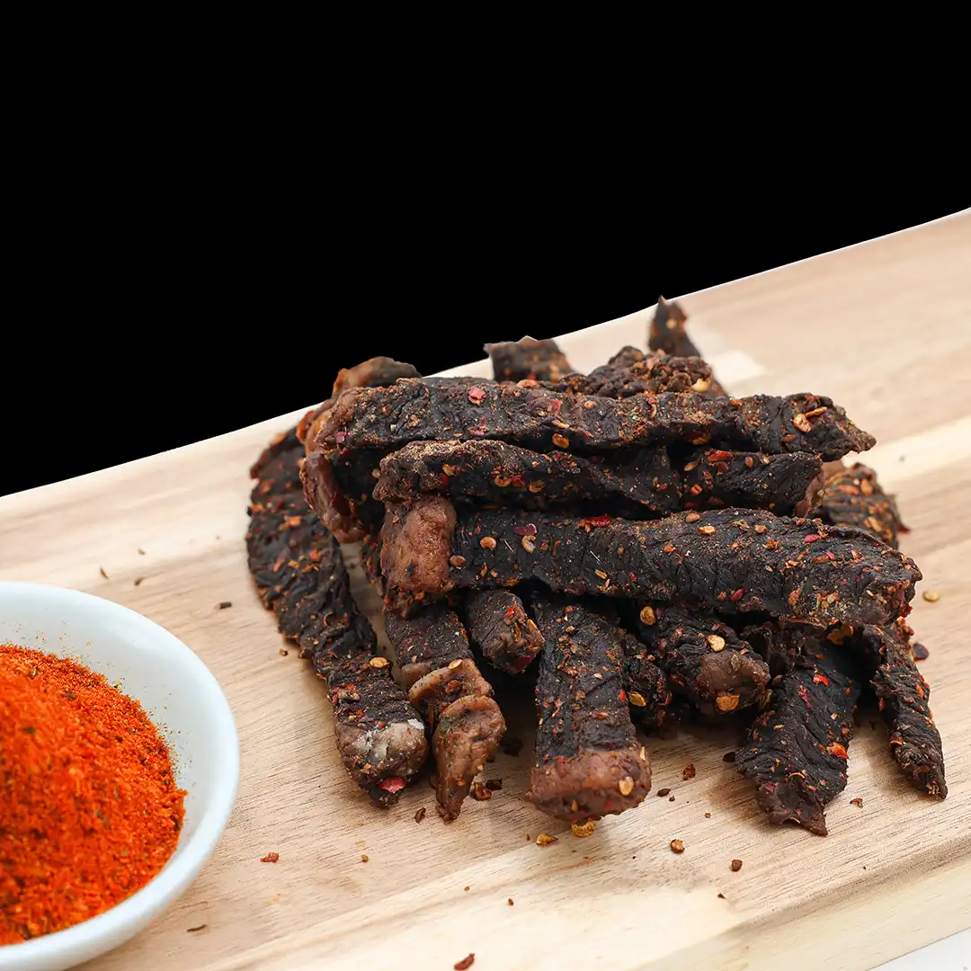 Spicy peri peri beef sticks with red spice coating at The Village Butcher.